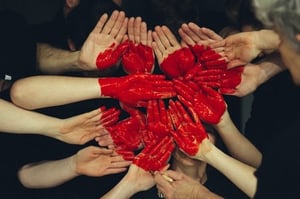 Collective hands painted with a red heart